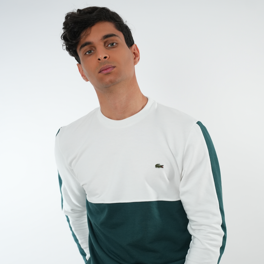 Modèle portant un sweatshirt LACOSTE en blanc et vert, alliant style et confort.