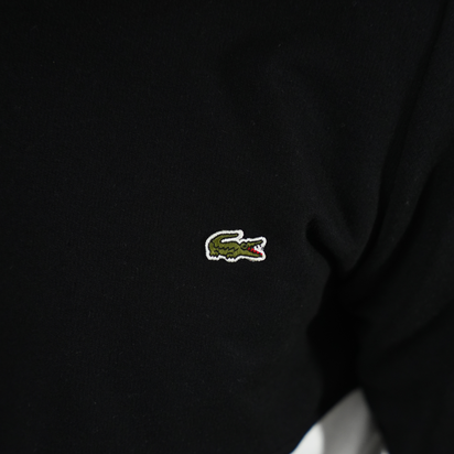 Détail de logo lacoste sur une veste de couleur noire, représentant la veste Lacoste élégante.